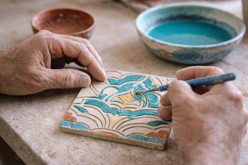 Artisan hand painting a decorative Malibu tile